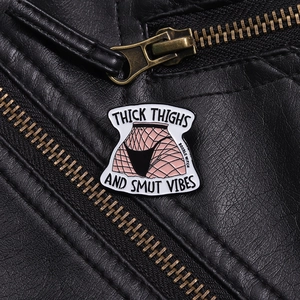 Détail du pin's en émail avec texte sur fond de textures en cuir noir élégant