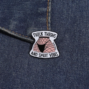 Gros plan d'un pin's en émail avec texte humoristique sur un tissu en jean bleu