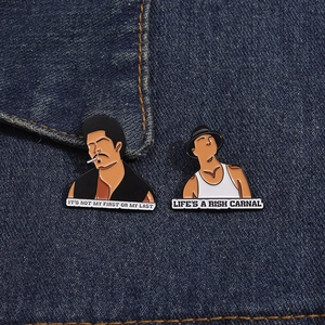 Close-up of enamel pins with movie character portraits on a denim jacket background