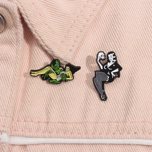 Detail view of gothic enamel pins featuring a green monster and a lady on a pink denim jacket