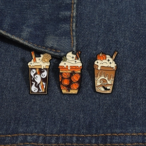 Vue détaillée de pins d'Halloween en émail avec motifs fantôme et citrouille sur denim