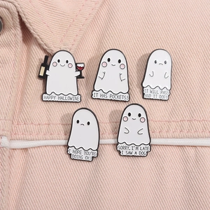 Detailset aus fünf Cartoon-Geist-Emaille-Pins an rosa Denim-Stoffmaterial gesteckt