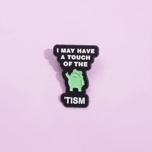Funny cartoon frog enamel pin with I May Have A Touch Of The Tism text on purple background