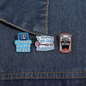 Detail view of funny cartoon enamel pins pinned on blue denim fabric background