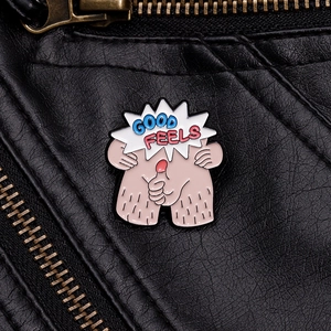 Macro shot of a creative enamel pin with 'GOOD FEELS' text on a black leather jacket