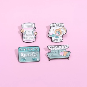 Set of 4 mental health enamel pins with medicine bottle and therapy sofa designs