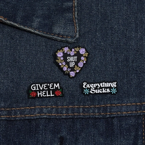 Détail de broches en émail avec slogans sur un tissu en denim bleu foncé