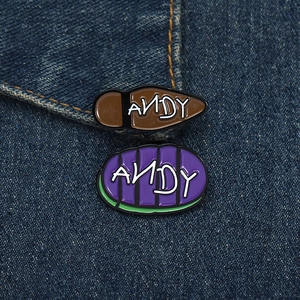 Detail view of Andy signature enamel pins on denim fabric from Toy Story movie