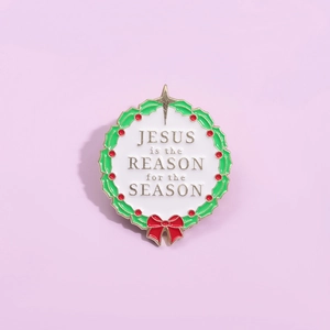 Christmas enamel pin with Jesus is the Reason for the Season text and holly leaves