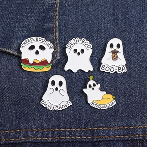 Close-up of five cute enamel ghost pins with pun text on dark blue denim fabric