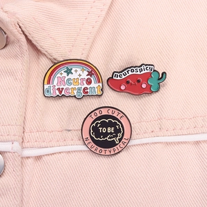Detailed enamel pins featuring neurospicy chili and neurodivergent designs on a pink denim jacket