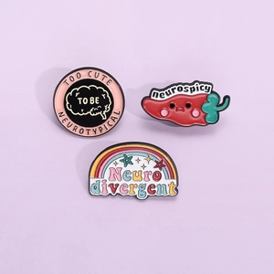 Three neurodiversity enamel pins including red chili and rainbow on purple background