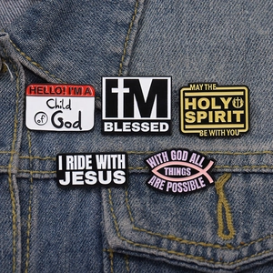 Lot de cinq broches chrétiennes en émail avec citations religieuses sur une veste en jean