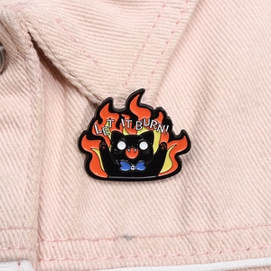 Detail of Let It Burn black cat enamel pin showing fire design on pink denim jacket