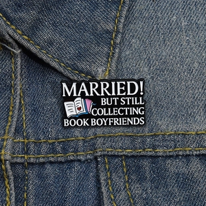 Détail d'un pin's en émail en forme de livre créatif sur un col de veste en jean