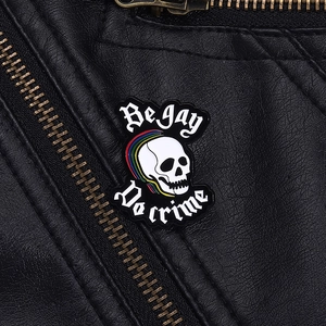 Détail du pin's émaillé Be Gay Do Crime avec mohawk arc-en-ciel sur veste en cuir