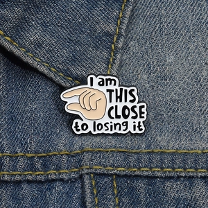 Funny enamel pin with hand gesture and I am THIS CLOSE to losing it text on denim