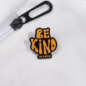 Close-up of a humor quote enamel pin with orange letters on a white canvas background