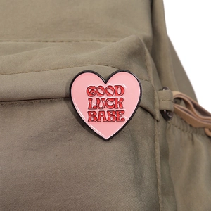 Broche en émail rose en forme de cœur Good Luck Babe sur un sac en nylon vert
