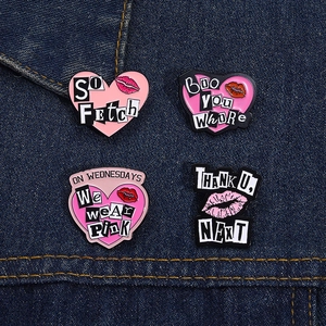 Détail de broches en émail rose en forme de cœur avec empreintes de lèvres sur denim