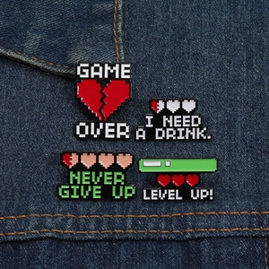 Detail of pixel art game pins on denim showing Heart and Level Up designs