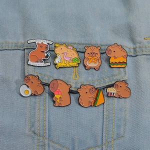 Detailansicht der Capybara-Emaille-Anstecknadeln auf einer Jeansjacke im Food-Design