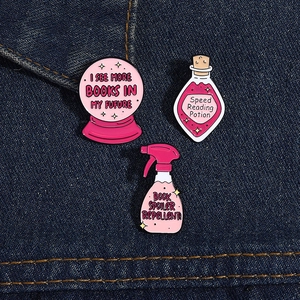 Detail view of pink enamel lapel pins with reading slogans on blue denim fabric