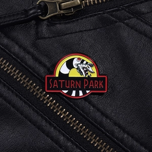 Macro detail of a Saturn Park snake enamel pin on a black leather jacket texture