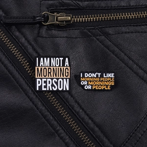 Detail of creative humor quote enamel pins on black leather texture background