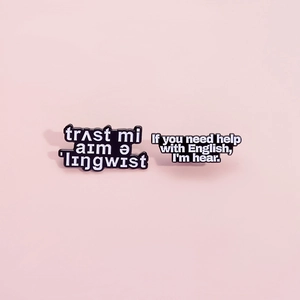 Funny black enamel linguist quote pins with punny text on a pink background