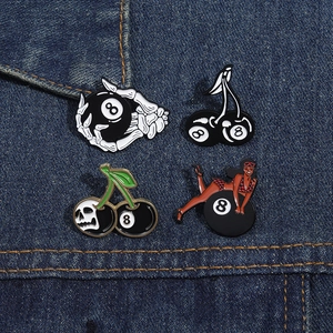 Detailed view of punk billiard skull and pin-up girl enamel pins on denim jacket