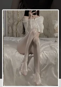 Glossy white pantyhose with pearl shimmer finish shown on legs in a home setting