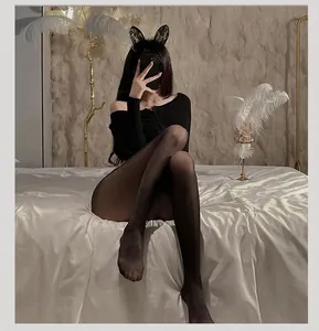 Detailed view of glossy black pantyhose paired with lace bunny ears in a stylish interior