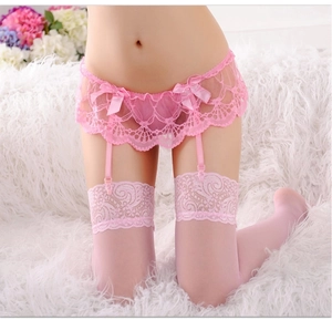Dettaglio del reggicalze in pizzo rosa con ricami floreali e delicati fiocchi decorativi