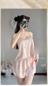Dettaglio del set pigiama in raso a fiori rosa con bordo in pizzo sul collo a V