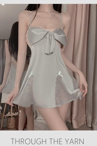 Détail de nuisette en satin argenté avec un grand nœud et des empiècements en dentelle