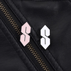 Macro view of pink and white Cool S enamel pins on black leather jacket texture