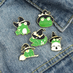 Lot de cinq pin's grenouilles en émail avec chapeaux de sorcier sur tissu en jean bleu