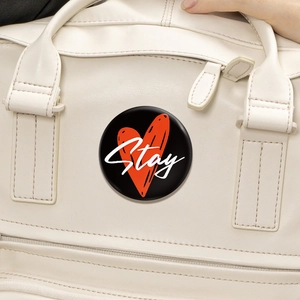 Spilla rotonda nera in latta con cuore rosso e scritta Stay su borsa in pelle crema