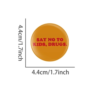 Détail du badge orange de 4,4 cm avec texte rouge disant non aux enfants et drogues