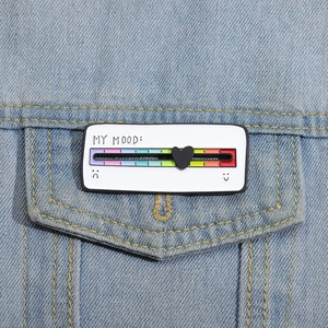 Détail d'une broche créative coulissante d'humeur épinglée sur une veste en jean