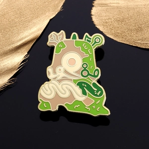 Artistic green and brown enamel pin brooch with gold trim on black mirror background