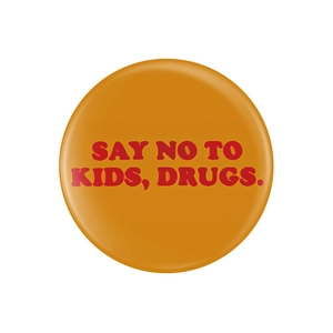 Vue détaillée du badge orange rond avec l'inscription humoristique SAY NO TO KIDS