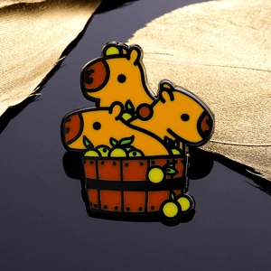 Creative enamel pin featuring three cute capybaras in a wooden bath with yuzu fruit