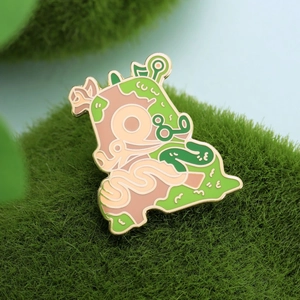 Cartoon Korok enamel pin badge in green and gold on moss background for clothing and bags