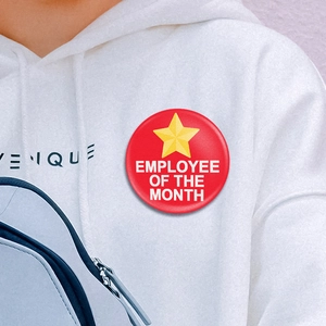 Badge rouge Employé du mois avec étoile dorée épinglé sur un sweat à capuche
