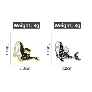 Detail of whale enamel pins showing weights of 3g and galaxy ocean space motifs