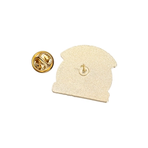 Détail de l'arrière d'une broche en métal avec fermoir papillon et texture sablée dorée