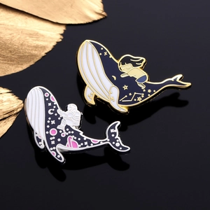 Galaxy Whale enamel pins featuring an astronaut and a girl on a reflective black background