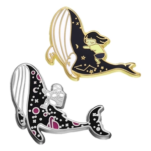 Enamel whale pins featuring astronaut and girl under stars on a minimalist white background